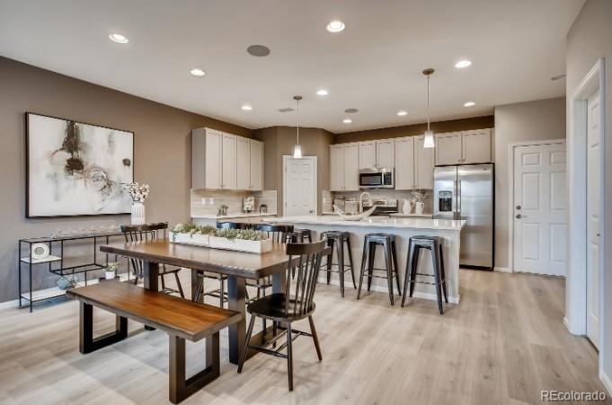a large kitchen with kitchen island a dining table chairs and white cabinets