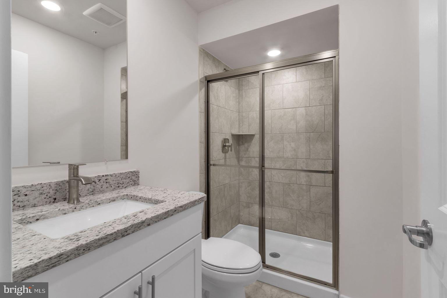 2216 Partin Road Windsor Mill, MD 21244 - Photo 20 of 25 a bathroom with a granite countertop sink a toilet and shower