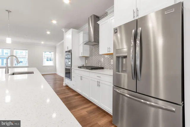a large kitchen with stainless steel appliances a refrigerator and a sink