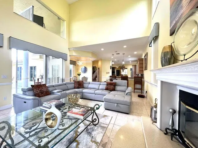a living room with furniture a fireplace and a large window