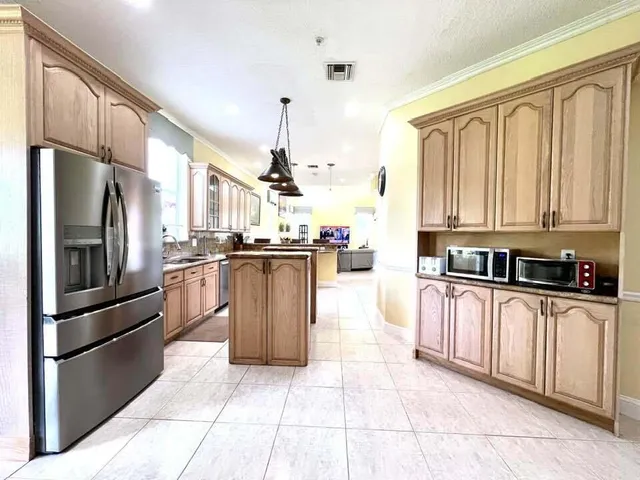 a kitchen with stainless steel appliances granite countertop a refrigerator a stove and a sink