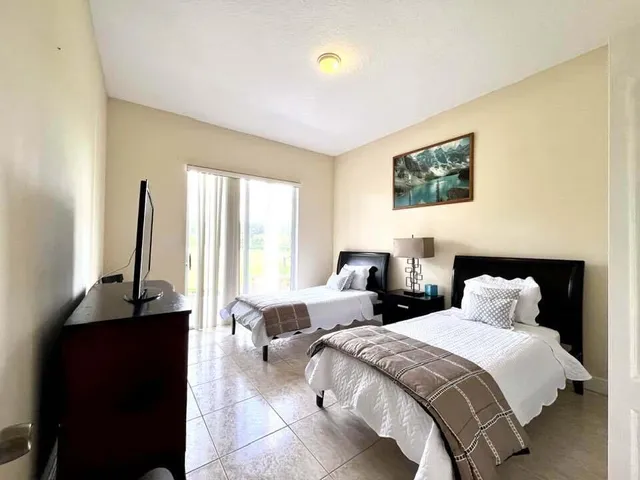 a bedroom with two beds and a flat screen tv