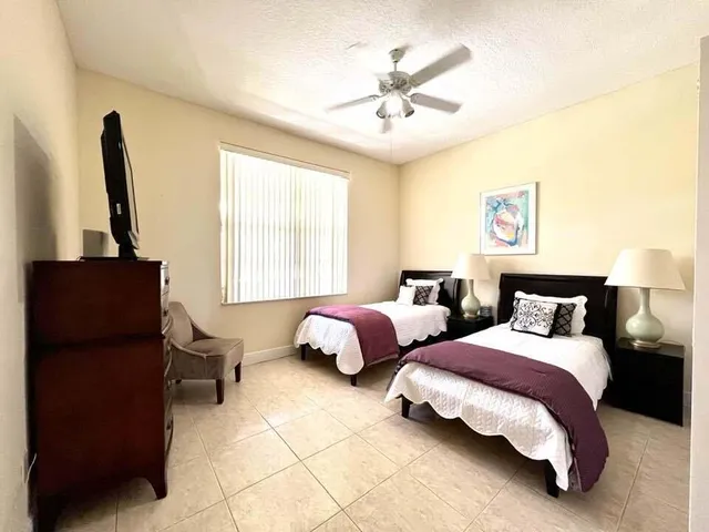 a spacious bedroom with two beds and a chandelier
