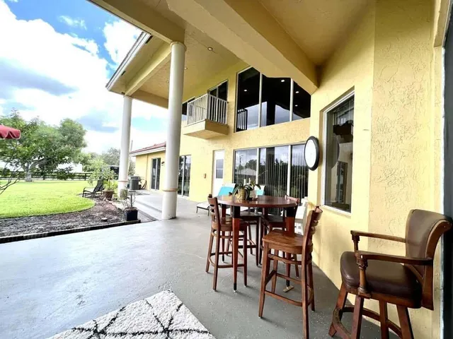 a view of a dinning table and chairs in patio of a house