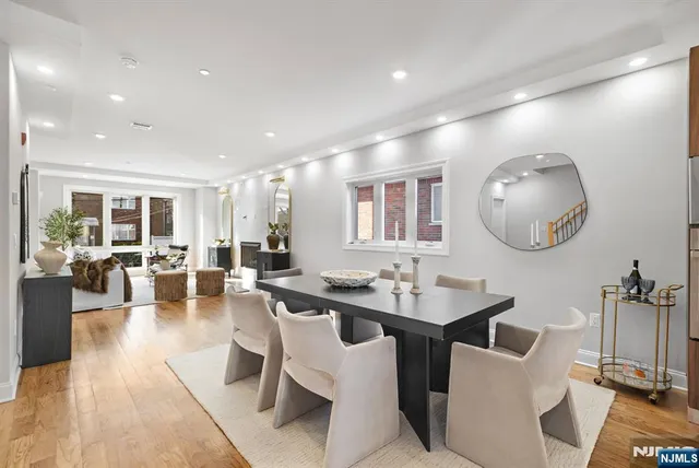 a dining room with wooden floor a glass table and chairs