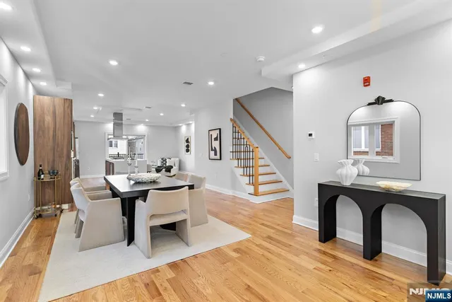 a dining room with wooden floor and a chandelier
