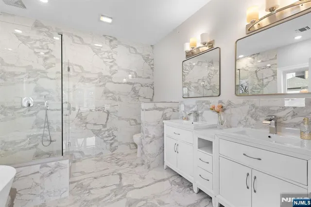 a bathroom with a double sink mirror and a shower