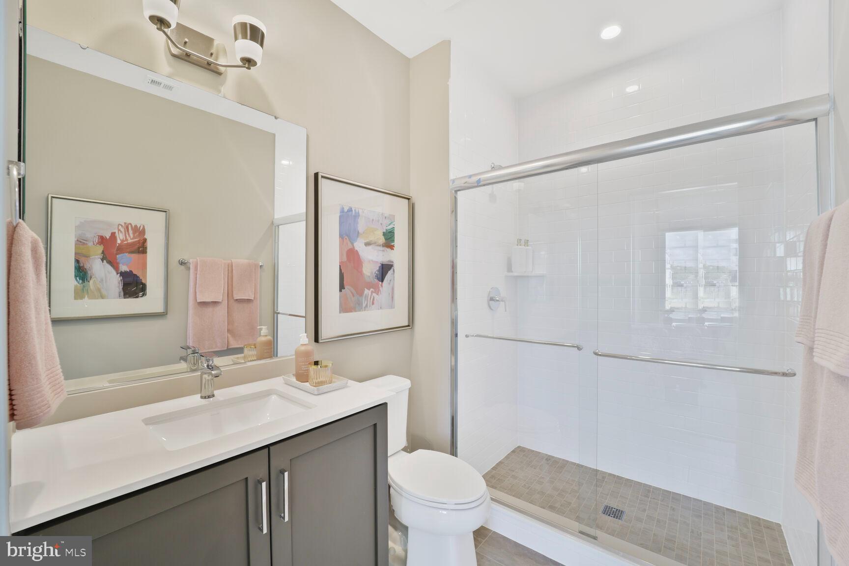 61 Lower Service Road Northwest, Unit ATWOOD 891 Washington, DC 20422 - Photo 12 of 21 a bathroom with a sink a toilet a shower and a mirror