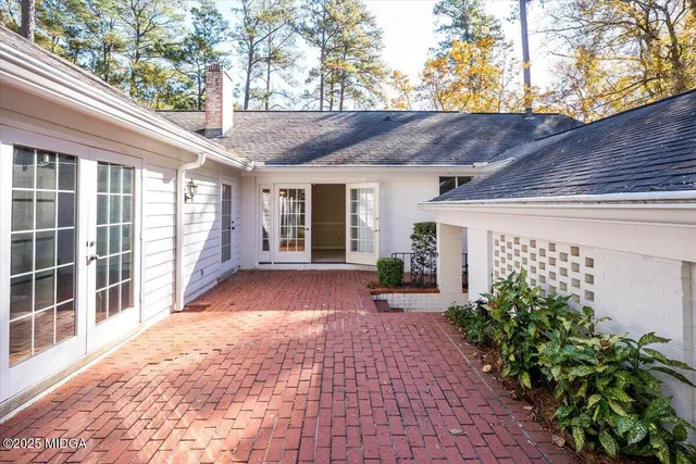 a view of a house with a yard and potted plants