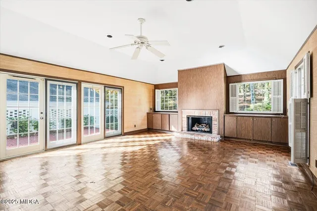 a view of an empty room with window and fire place