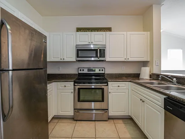 a kitchen with cabinets stainless steel appliances and a sink