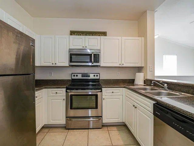 a kitchen with cabinets stainless steel appliances and a sink