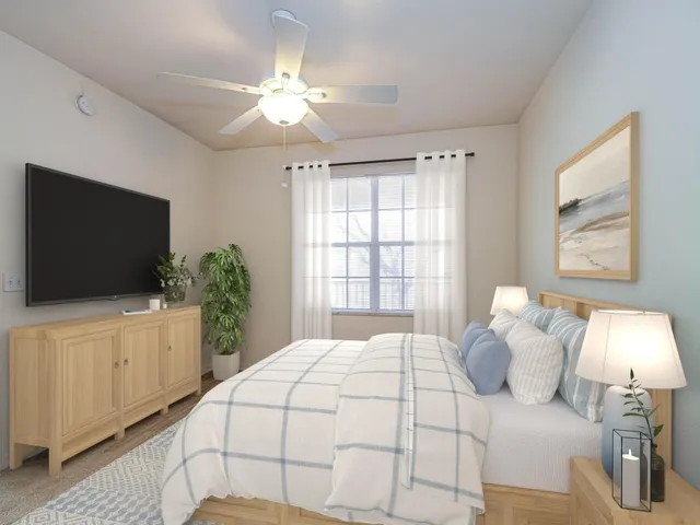 a bedroom with a large bed and a flat tv screen on dresser