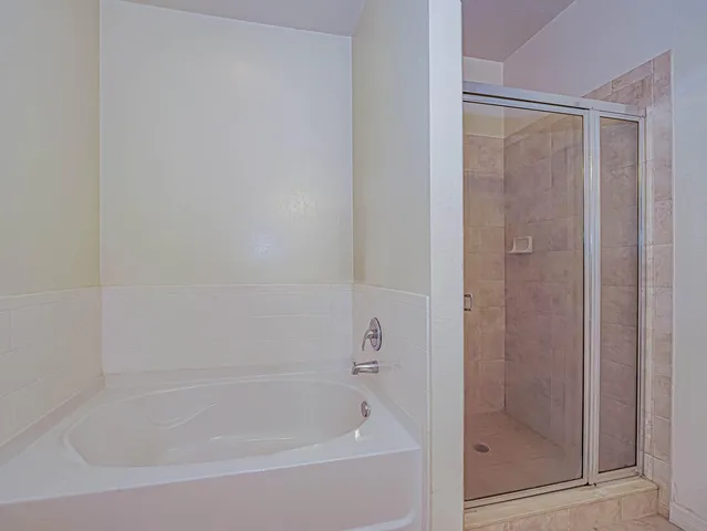 a white bath tub sitting next to a shower