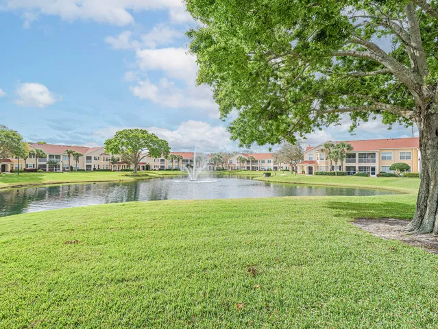 a view of a house with a yard and a fountain