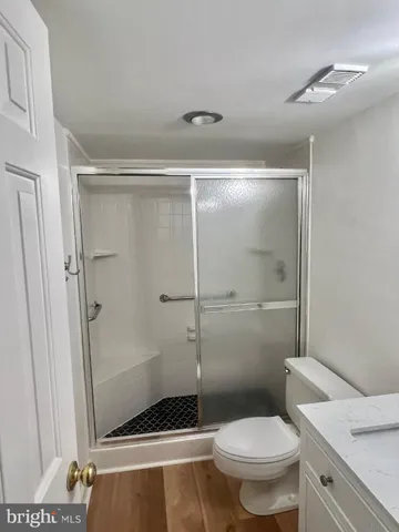 a bathroom with a granite countertop toilet and a shower