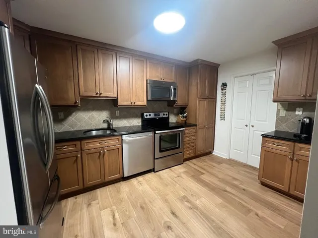 a kitchen with granite countertop stainless steel appliances a refrigerator sink and microwave