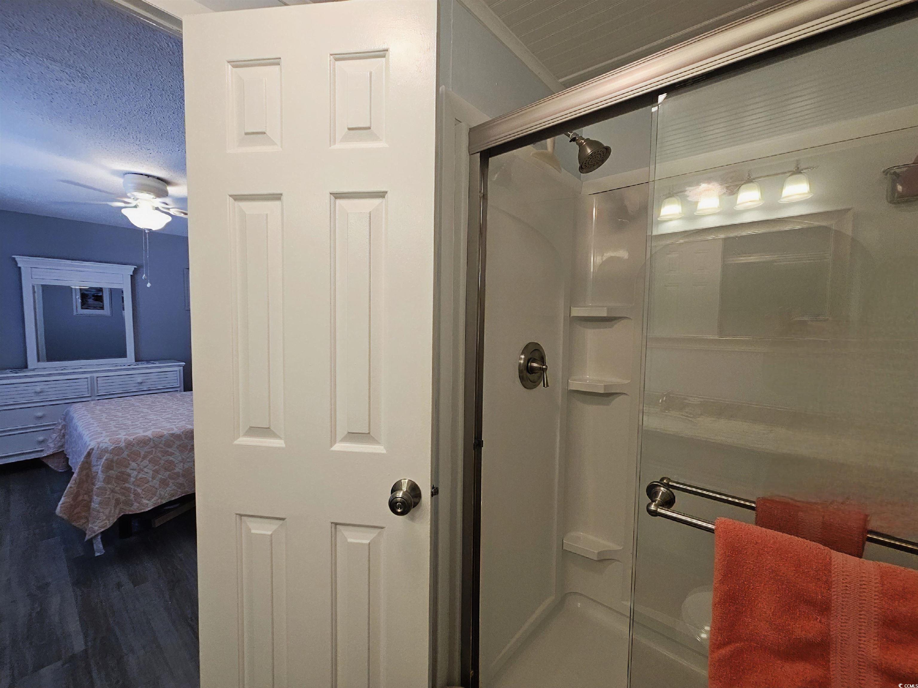 355 Meadowlark Surfside Beach, SC 29575 - Photo 14 of 39 Bathroom featuring a stall shower, dark wood-type flooring, ceiling fan, connected bathroom, and a textured ceiling