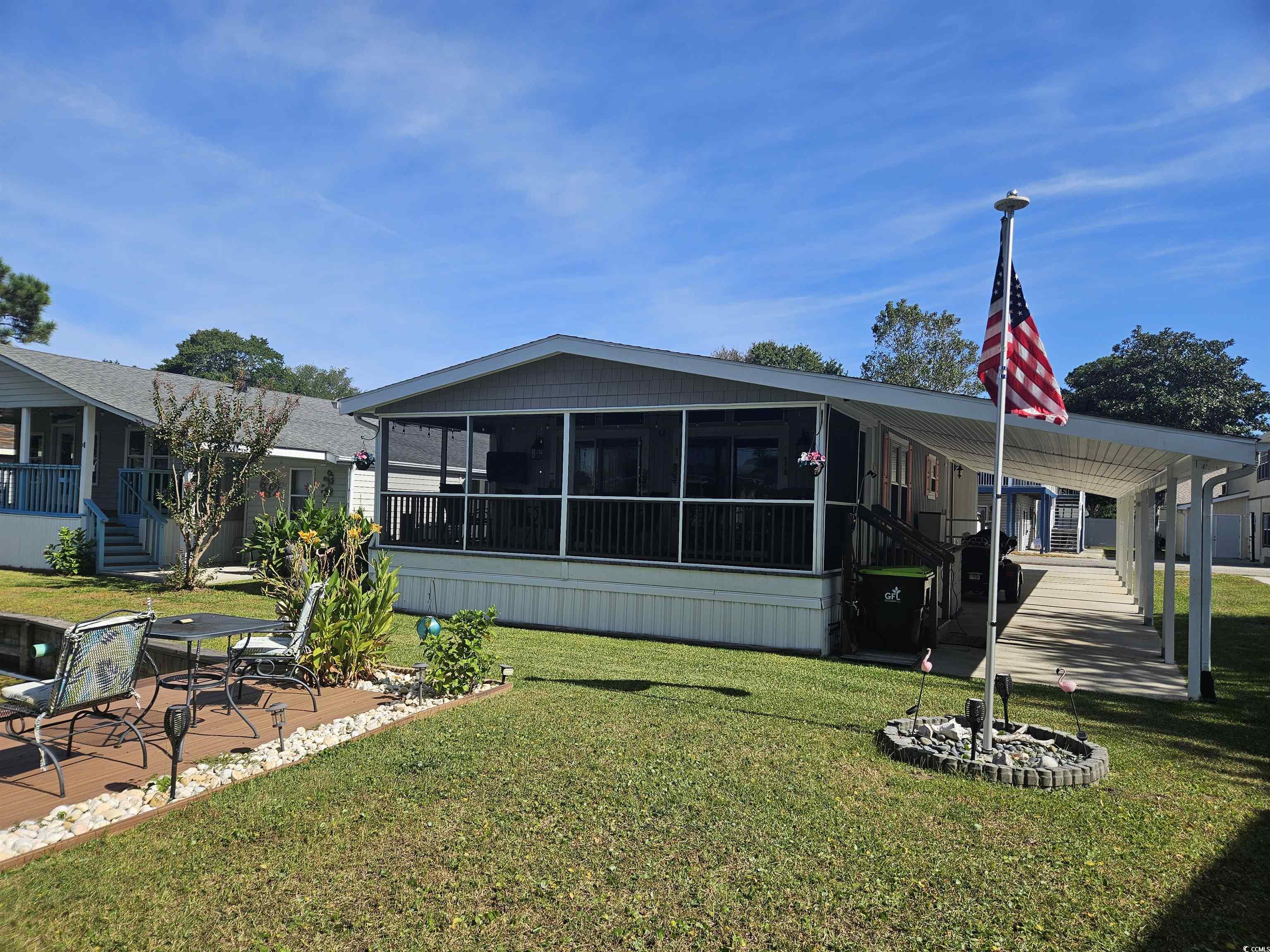 355 Meadowlark Surfside Beach, SC 29575 - Photo 24 of 39 Rear view of house with a sunroom, a yard, a patio area, and a deck