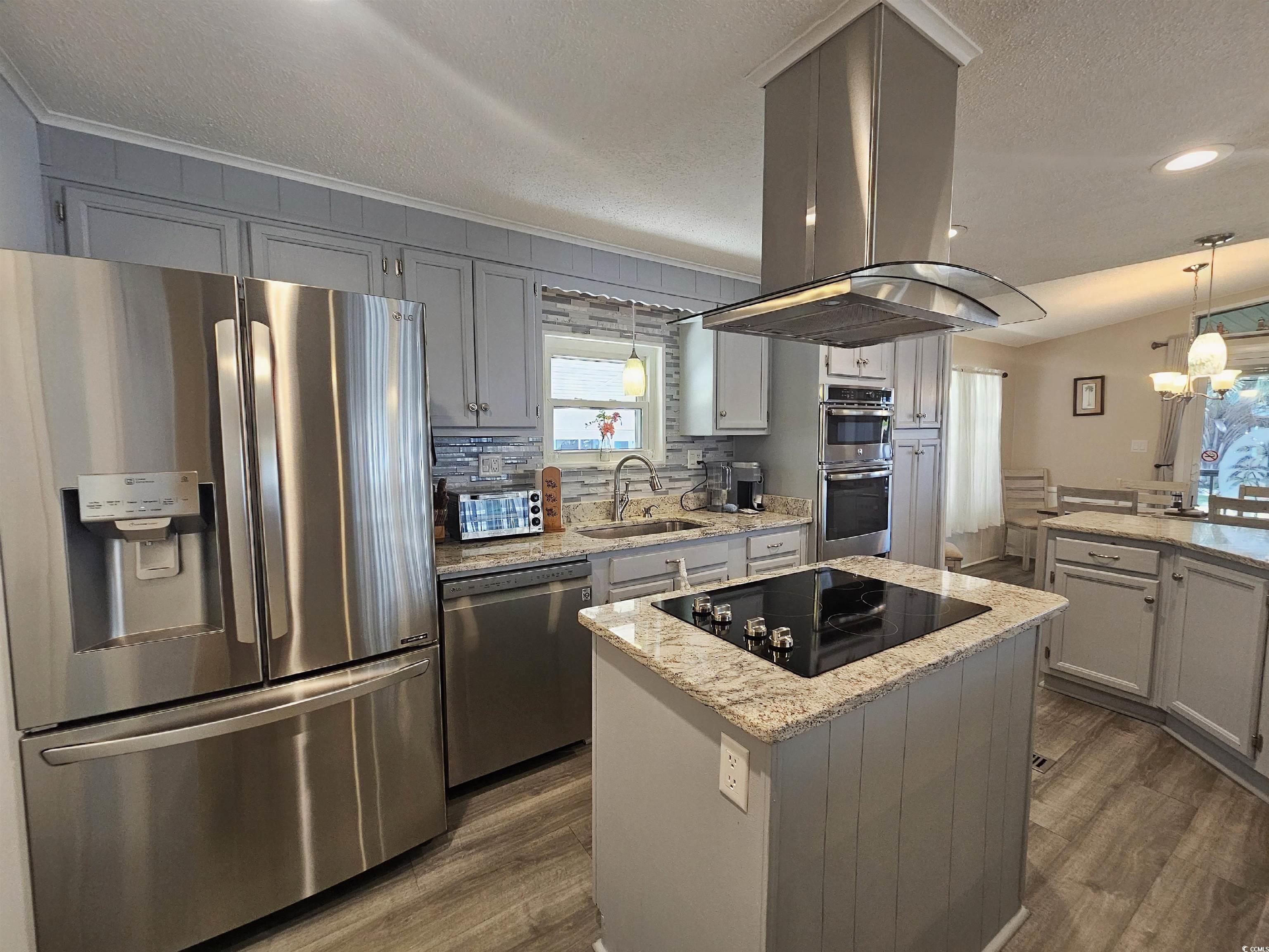 355 Meadowlark Surfside Beach, SC 29575 - Photo 2 of 39 Kitchen featuring stainless steel appliances, gray cabinets, light stone countertops, island range hood, and a textured ceiling