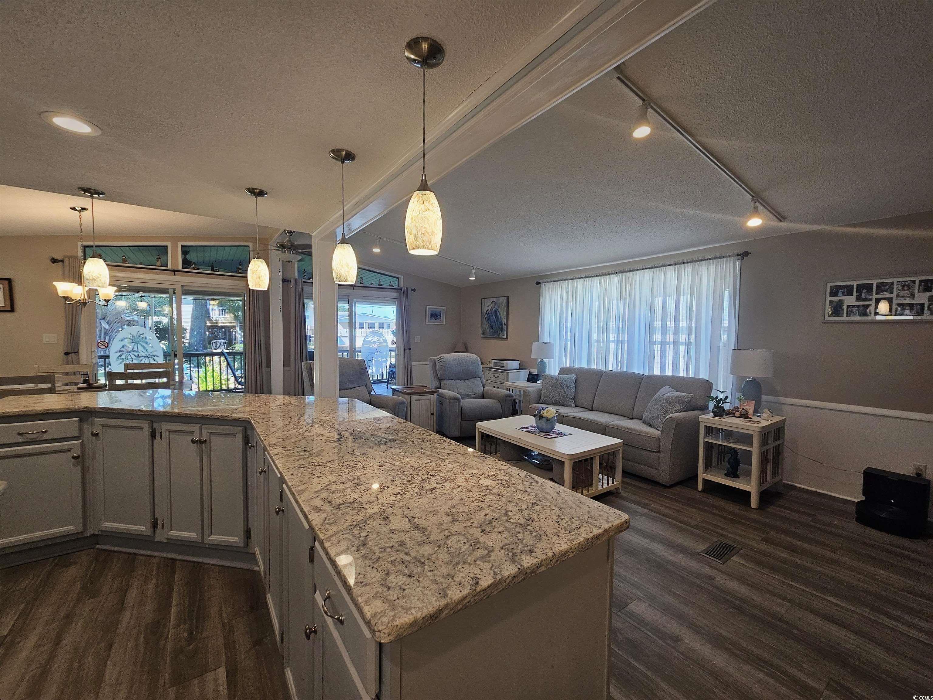 355 Meadowlark Surfside Beach, SC 29575 - Photo 3 of 39 Kitchen featuring a textured ceiling, decorative light fixtures, healthy amount of natural light, and light stone counters