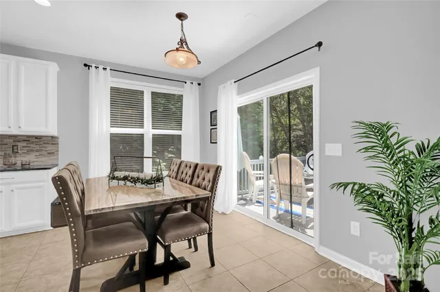 a dining room with furniture a chandelier and wooden floor