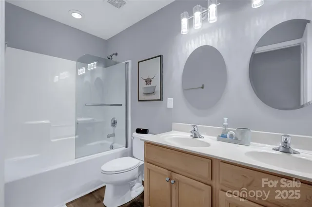 a bathroom with a toilet a sink a mirror a bathtub and vanity