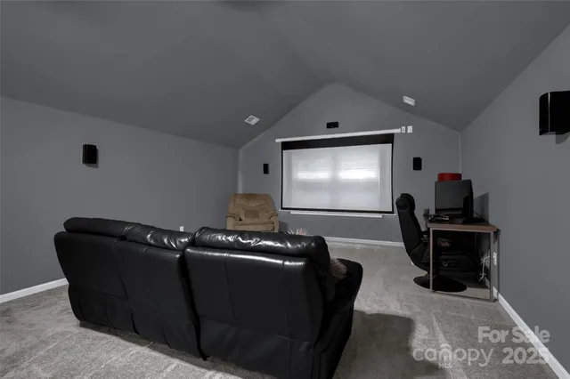 a living room with furniture a projector and screen