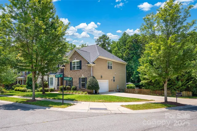 a view of a house with a big yard and large trees