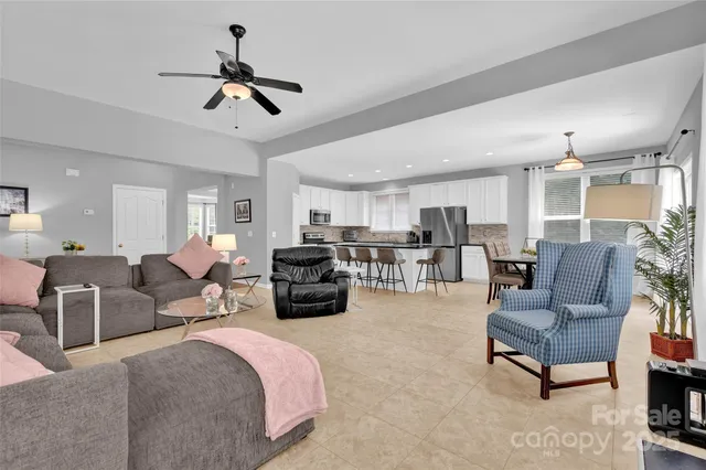 a living room with furniture kitchen view and a chandelier