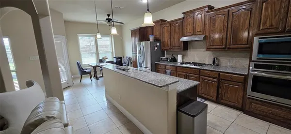a kitchen with granite countertop a sink stove and refrigerator