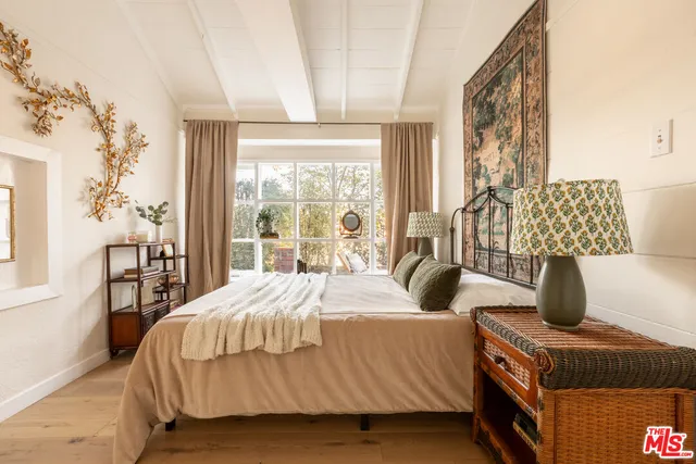 a bedroom with a bed and a large window with outer view