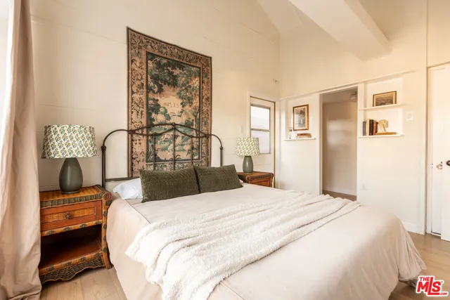 a bedroom with a bed and dresser with mirror