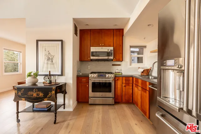 a kitchen with stainless steel appliances a stove top oven a sink and a refrigerator