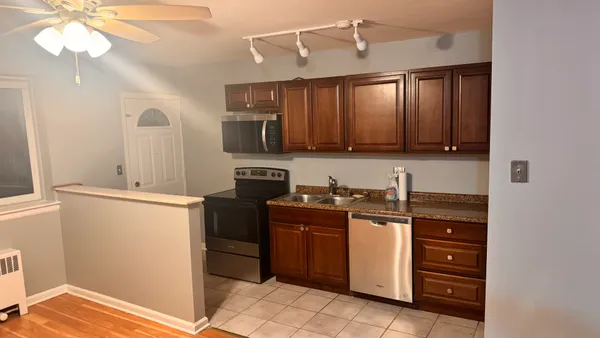 a kitchen with stainless steel appliances granite countertop a stove a sink and a refrigerator