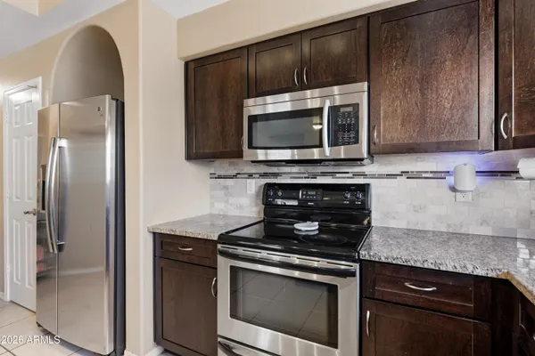 a kitchen with granite countertop wooden cabinets and stainless steel appliances