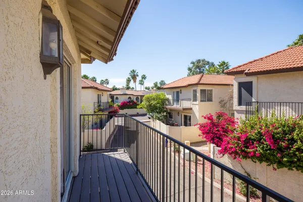 a view of a house with wooden deck and furniture
