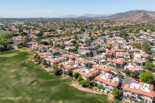 an aerial view of residential houses with outdoor space and trees
