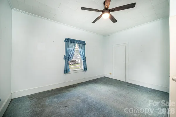 an empty room with a window and a ceiling fan