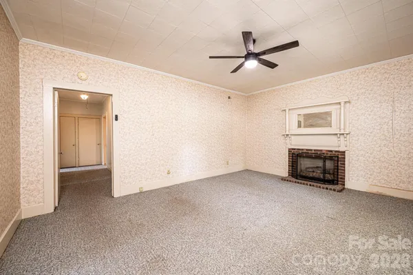 a view of a livingroom with a ceiling fan and fireplace