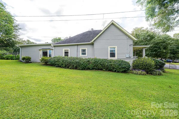 a view of a house with backyard and sitting area