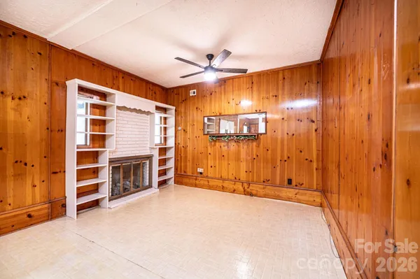 a view of an empty room with a fireplace and a window