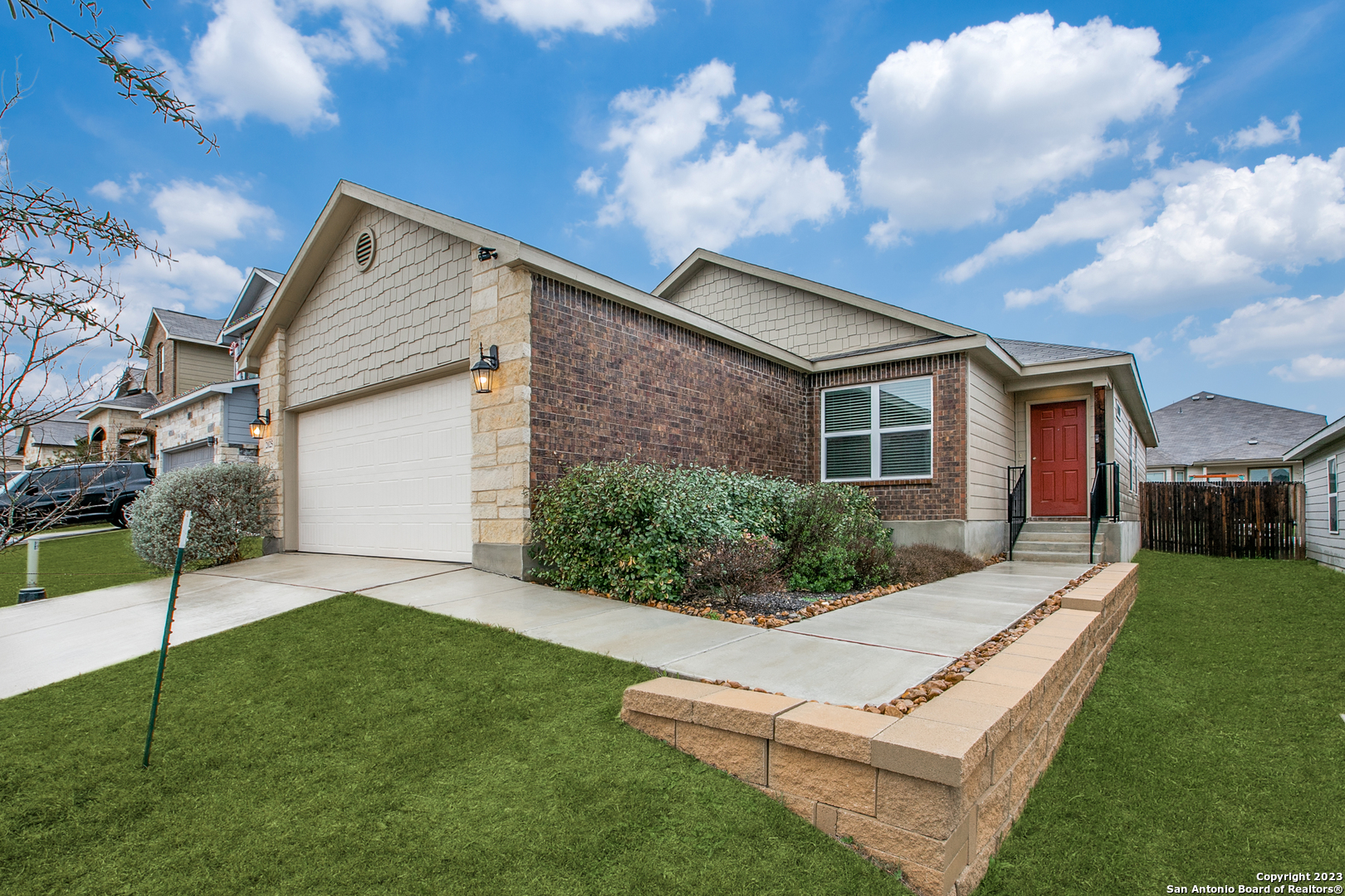 a view of a white house with a big yard and potted plants