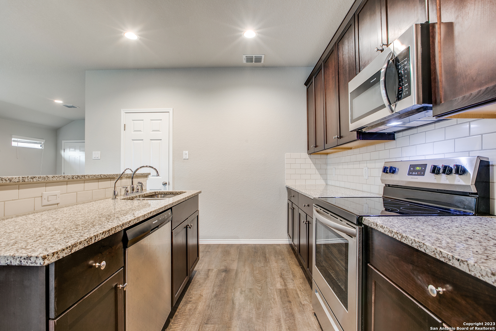 2025 Rhesus View San Antonio, TX 78245 - Photo 5 of 13 a kitchen with granite countertop stainless steel appliances and wooden cabinets