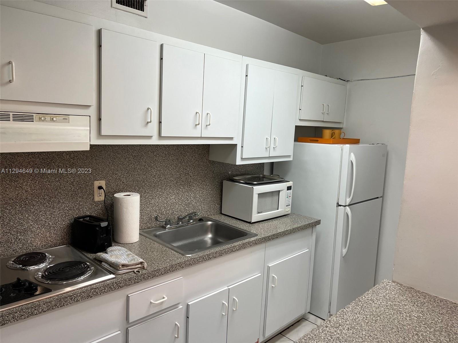 100 Lincoln Road, Unit 1001 Miami Beach, FL 33139 - Photo 14 of 62 a kitchen with stainless steel appliances granite countertop a refrigerator sink and white cabinets