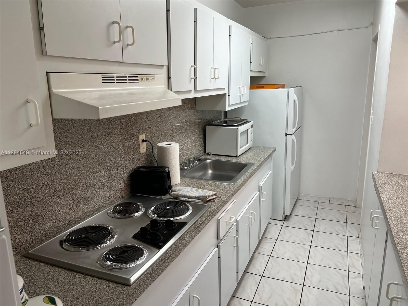 100 Lincoln Road, Unit 1001 Miami Beach, FL 33139 - Photo 16 of 62 a kitchen with a stove and a refrigerator