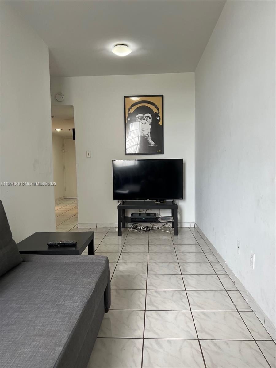 100 Lincoln Road, Unit 1001 Miami Beach, FL 33139 - Photo 5 of 62 a living room with a couch and a flat screen tv