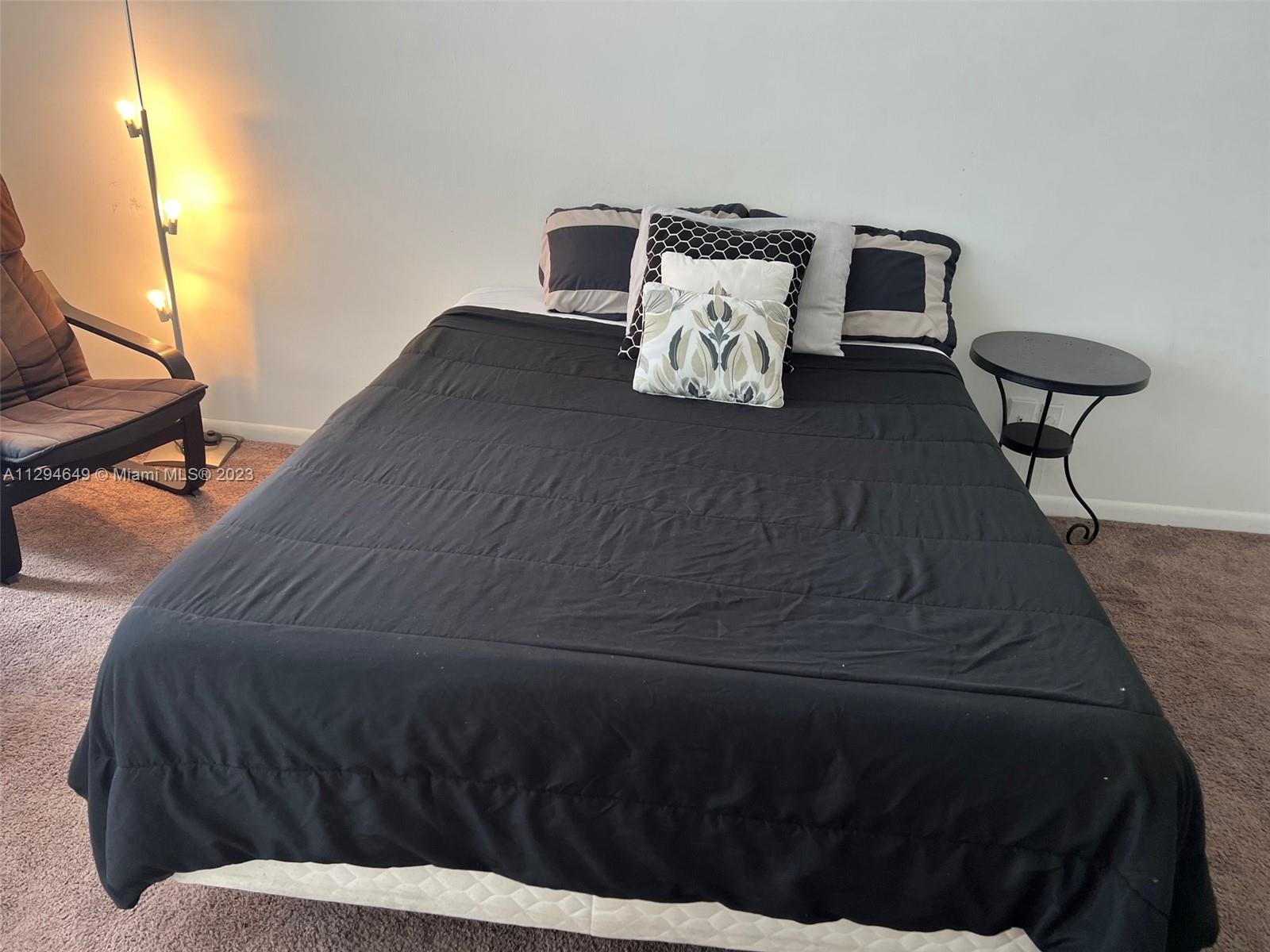 100 Lincoln Road, Unit 1001 Miami Beach, FL 33139 - Photo 9 of 62 a bed sitting in a bedroom next to a lamp