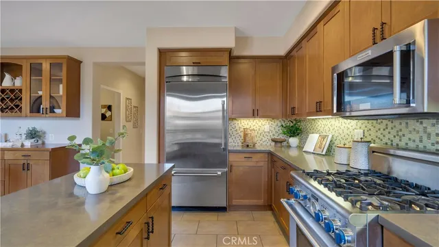 a kitchen with stainless steel appliances granite countertop a sink a stove and a wooden floors