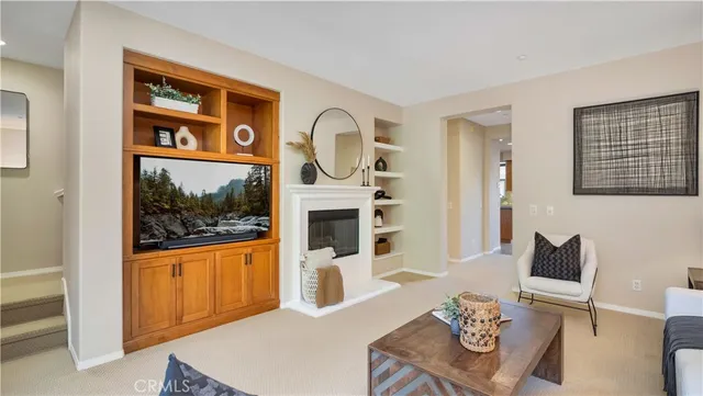 a living room with furniture a flat screen tv and a fireplace